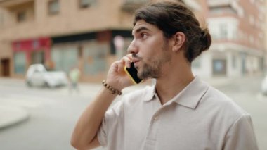 Genç İspanyol adam gülümsüyor. Kendine güveniyor. Sokakta akıllı telefondan konuşuyor.