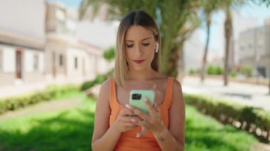 Genç, güzel, İspanyol bir kadın, gülümsüyor. Parkta kendine güvenen bir video var.