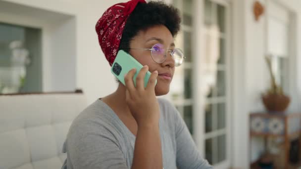 기사보기 아프리카 미국인 테라스에서 스마트폰으로 통화하는 — 비디오