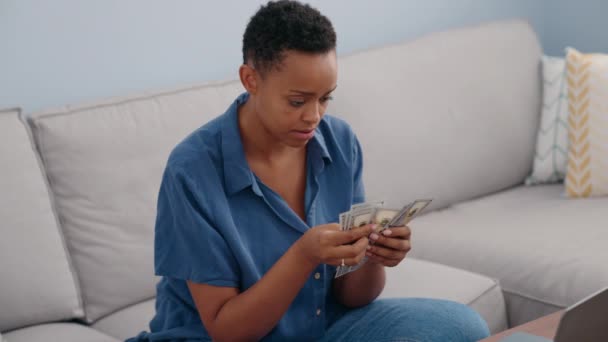 非洲裔美国女人坐在家里的沙发上数钱 — 图库视频影像