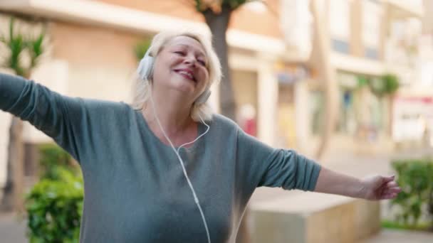 Блондинка Средних Лет Слушает Музыку Смартфона Танцует Улице — стоковое видео