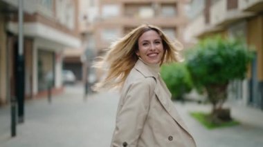 Young blonde woman smiling confident walking at street