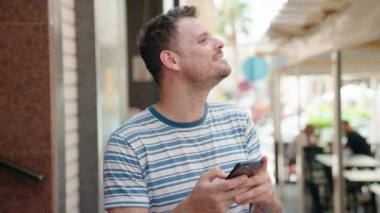 Sokakta akıllı telefon kullanan, kendine güvenen genç bir İspanyol.