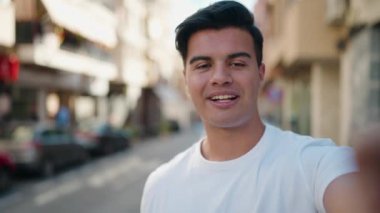 Latin asıllı genç adam gülümsüyor.