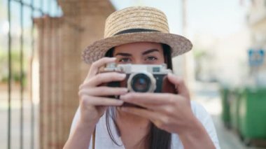 Sokak kamerasıyla gülümseyen Latin kökenli genç bir turist.
