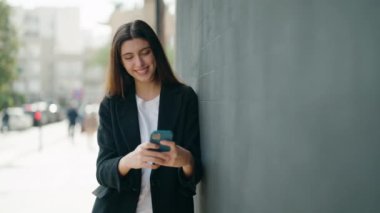 Sokakta akıllı telefon kullanan kendine güvenen genç İspanyol kız.