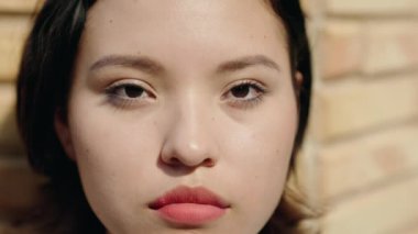 Young hispanic woman standing with serious expression at street