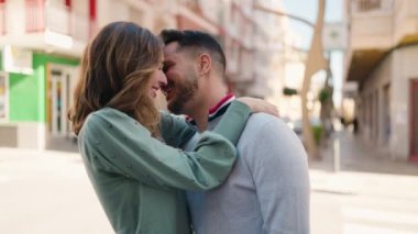 Young couple kissing and hugging each other standing at street