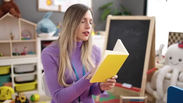 Young Blonde Woman Preschool Teacher Reading Book Kindergarten — Vídeo de stock