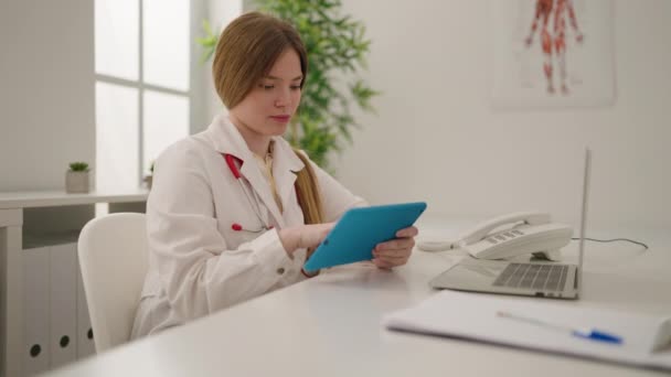 Jovem Loira Vestindo Uniforme Médico Usando Touchpad Clínica — Vídeo de Stock