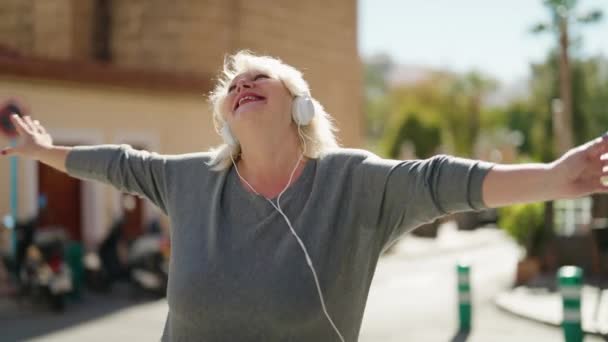 Mulher Loira Meia Idade Ouvindo Música Usando Smartphone Dançando Rua — Vídeo de Stock