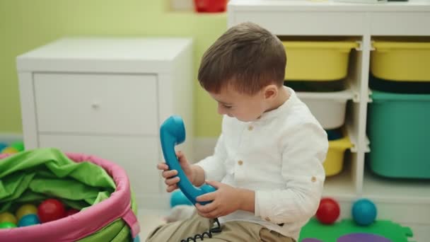Uroczy Kaukaski Chłopiec Bawiący Się Telefon Zabawka Siedzi Podłodze Przedszkole — Wideo stockowe