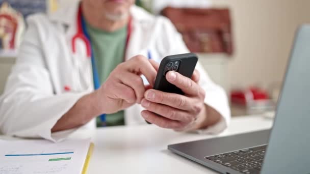 Médico Cabelos Grisalhos Meia Idade Usando Smartphone Laptop Trabalhando Clínica — Vídeo de Stock