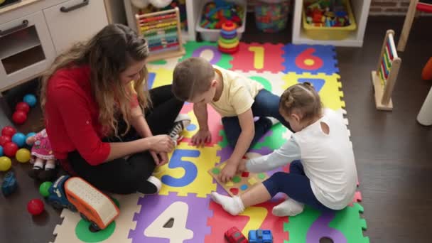 Δάσκαλος Αγόρι Και Κορίτσι Παίζει Μαθηματικά Παιχνίδι Παζλ Κάθεται Στο — Αρχείο Βίντεο