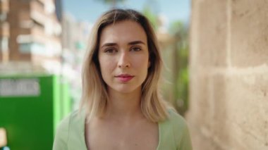 Sokakta kendinden emin gülümseyen genç bir kadın.