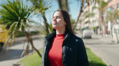 Young woman smiling confident breathing at park