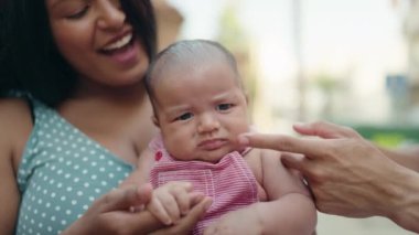 İspanyol ailesi gülümsüyor. Sokakta birbirlerine sarılıyorlar.