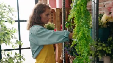 Çiçekçide raf düzenleyen güzel İspanyol kadın.