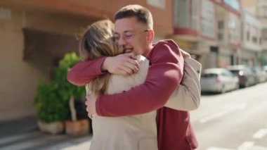 Erkek ve kadın anne ve oğul sokakta birbirlerine sarılıyorlar.