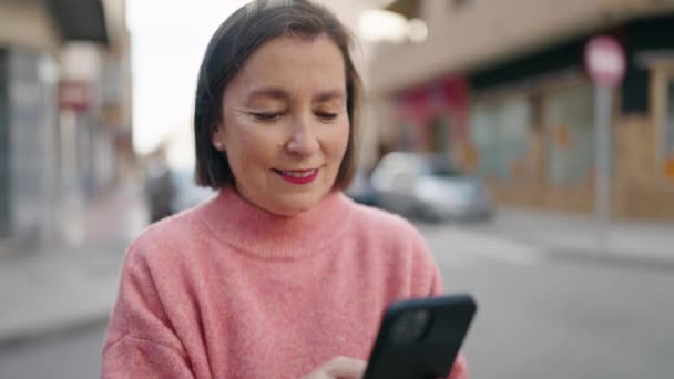 Sokakta Akıllı Telefon Kullanan Orta Yaşlı Bir Kadın Gülümsüyor — Stok video