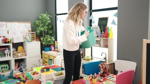 Young Blonde Woman Preschool Teacher Picking Toys Kindergarten — Stok video