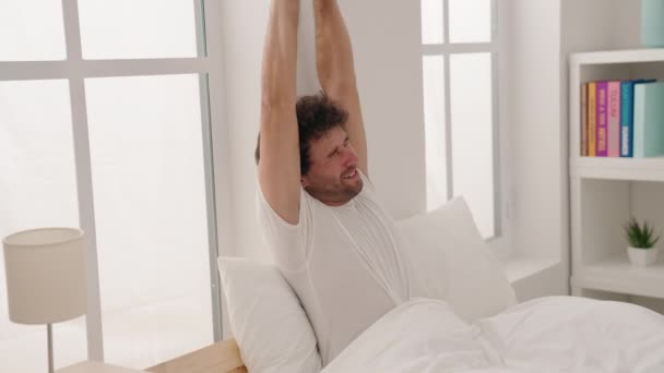 Young Hispanic Man Waking Stretching Arms Bedroom — 图库视频影像