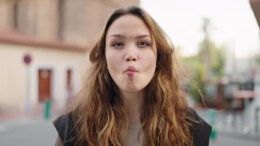 Genç İspanyol kadın gülümsüyor. Kendine güveni tam. Komik hareketler yapıyor.