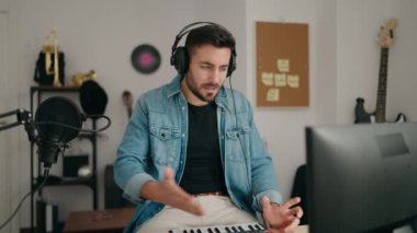 Genç İspanyol ressam gülümsüyor. Müzik stüdyosunda kendine güvenen biri.