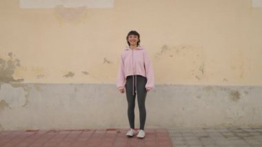 Genç İspanyol kadın gülerek caddeye atlıyor.