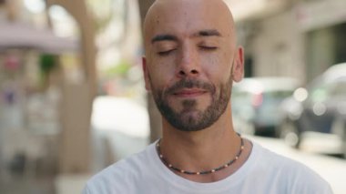 Genç kel adam gülümsüyor. Kendine güveniyor.