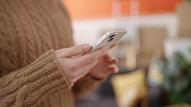 Yeni evinde akıllı telefon kullanan güzel bir İspanyol kadın.