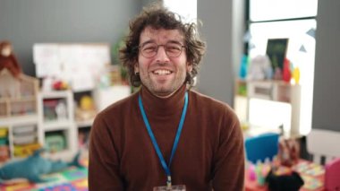 Genç İspanyol anaokulu öğretmeni anaokulunda kendinden emin bir şekilde gülümsüyor.