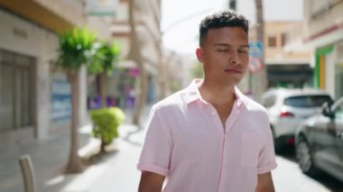 Sokakta yürüyen rahat yüzlü genç bir latin.