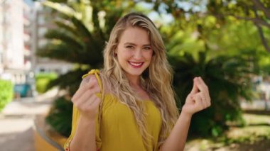 Kendine güvenen genç bir kadın parkta para harcıyor.