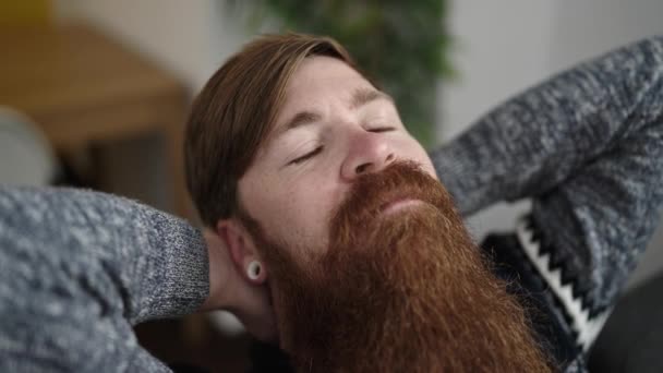 Ung Rødhåret Mand Afslappet Med Hænderne Hovedet Sidder Sofaen Derhjemme – Stock-video