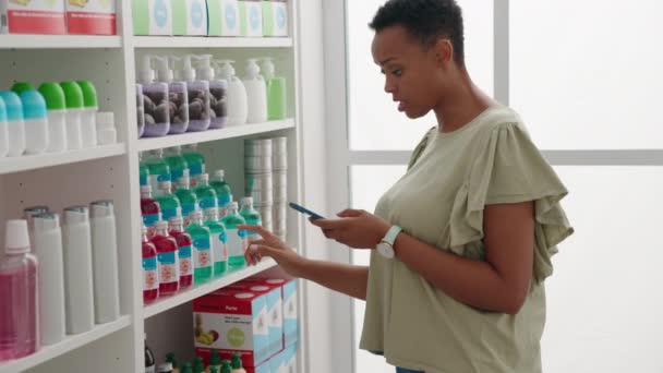 African American Woman Customer Using Smartphone Holding Medicine Bottle Pharmacy — Stock Video