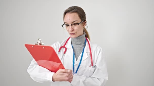 年轻的高加索女医生在隔离的白色背景下阅读剪贴板上的文档 — 图库视频影像