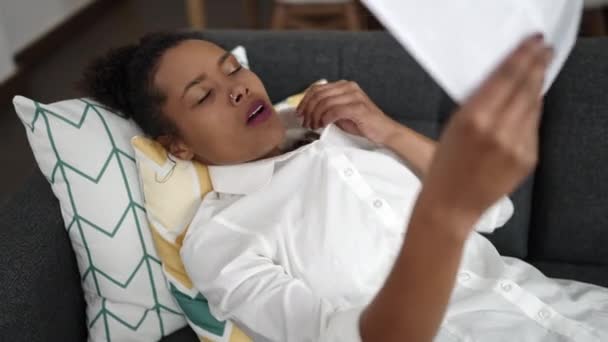 Африканська Американка Лежала Дивані Виготовляючи Повітря Паперу Вдома — стокове відео
