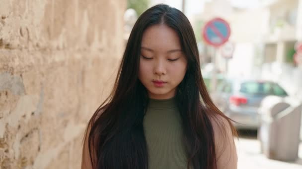 中国的年轻女子站在那里严肃地看着街上的摄像机 — 图库视频影像