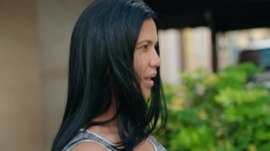 Orta yaşlı İspanyol kadın sokakta kendine güvenerek gülümsüyor.