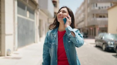 Genç İspanyol kız akıllı telefonla konuşuyor caddede yürürken