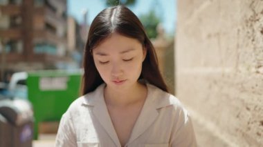 Sokakta duran rahat yüzlü Çinli kadın.