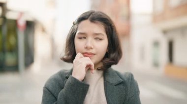 Şüpheli bir ifadeyle sokakta duran genç İspanyol kız.