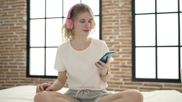 Dans Eden Müzik Dinleyen Genç Sarışın Kadın Yatak Odasında Oturuyor — Stok video