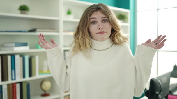 Junge Blonde Studentin Steht Mit Verwirrtem Gesichtsausdruck Der Bibliothek — Stockvideo