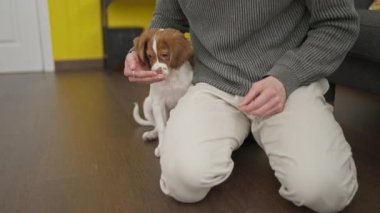 Evde köpeğiyle yerde oturan iki erkek.