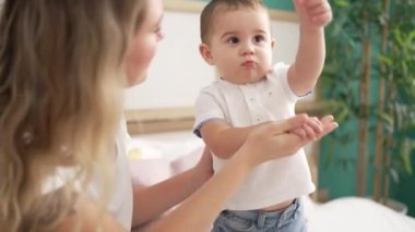 Anne ve oğul yatak odasında oynuyorlar.