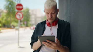 Genç beyaz adam gülümsüyor. Kendine güveni tam. Sokakları işaret ediyor.