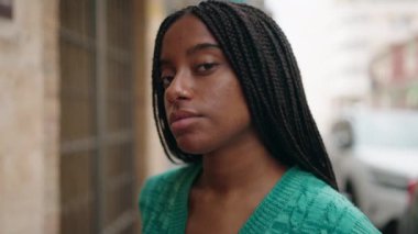 Sokakta rahat bir ifadeyle dikilen Afrikalı Amerikalı kadın.