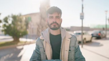 Genç İspanyol adam gülümsüyor. Kendine güveni tam. Sokakta çapraz hareketlerle duruyor.